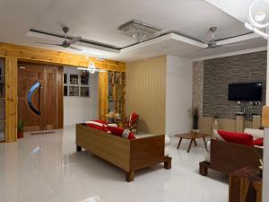 a living room with two couches and a tv at Newsy Inn in Hithadhoo