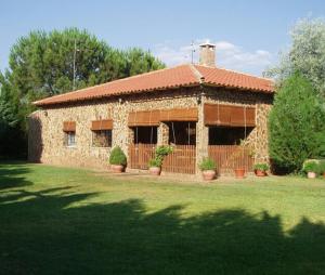 a large stone house with a grass yard at Los Jabones in Ciudad Real
