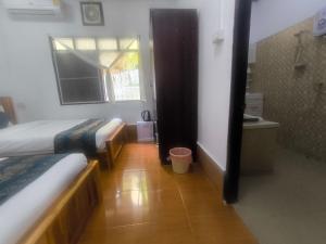 a small room with two beds and a bathroom at Chalern Guesthouse in Luang Prabang