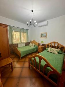 a bedroom with two beds and a chandelier at Los Jabones in Ciudad Real
