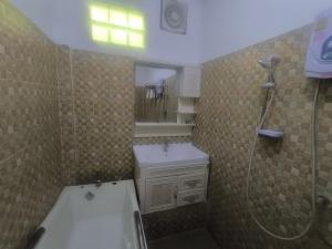 a bathroom with a shower and a sink and a tub at Chalern Guesthouse in Luang Prabang