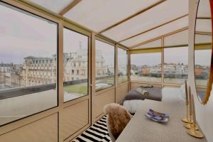 a room with a bed and a balcony with windows at Loft Duplex Terrasse View on Paris in Paris