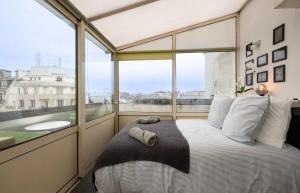 a bed in a room with a large window at Loft Duplex Terrasse View on Paris in Paris