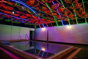 a room with a pool with colorful lights on the ceiling at French Villa in Dankotuwa
