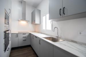 a white kitchen with a sink and a refrigerator at Zambra en Cádiz in Cádiz