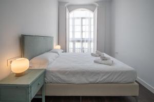 a bedroom with a bed with a table and a window at Zambra en Cádiz in Cádiz