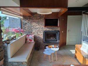 a living room with a fireplace and a stone wall at Campus Natura in Arganil