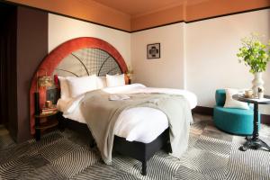 a bedroom with a large bed and a blue chair at Jan Luyken Amsterdam in Amsterdam