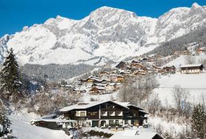 a mountain village covered in snow with mountains in the background at Apartments Helsen in Mühlbach am Hochkönig