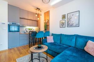 a living room with a blue couch and a kitchen at Zlatibor 2 in Zlatibor