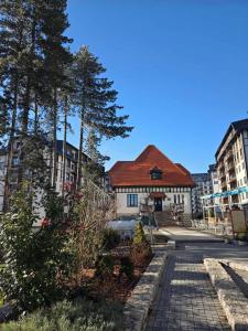 a building with a red roof on a street at Zlatibor 2 in Zlatibor