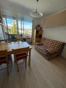a living room with a table and a couch at Hirmentaz in Bellevaux