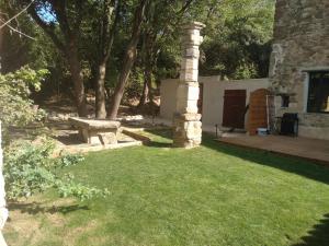 a garden with a stone pillar and a bench at Les feuillets de la Buire in Monteux +22 photos