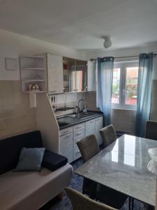 a kitchen and living room with a table and a couch at Lion Apartments in Vodice