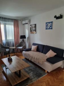 a living room with a blue couch and a table at Lion Apartments in Vodice