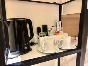 a coffee maker and coffee cups on a shelf at Star Mews Hotel Changkat Bukit Bintang in Kuala Lumpur
