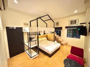 a bedroom with a bed and a room with a chair at Star Mews Hotel Changkat Bukit Bintang in Kuala Lumpur