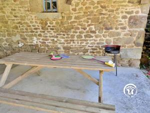 a wooden table with tools on it next to a brick wall at La grande reignière in Brécé