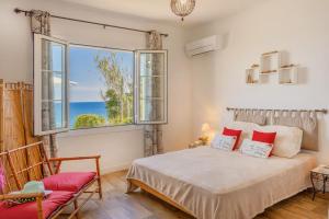 a bedroom with a bed and a view of the ocean at Villa Erbalunga in Erbalunga