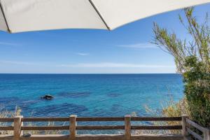 a view of the ocean from a beach under an umbrella at Villa Erbalunga in Erbalunga +30 photos