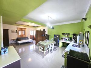 eine Küche mit grünen Wänden und einem Tisch in einem Zimmer in der Unterkunft Real House in Real