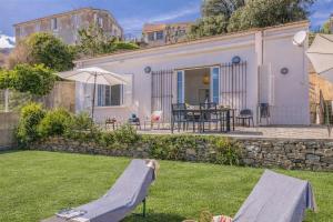 a small house with a stone wall and a yard at Villa Erbalunga in Erbalunga