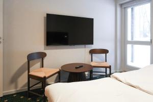 a hotel room with two chairs and a table and a tv at Faxe Ladeplads Motel in Hylleholt