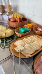 a table with plates of food and bowls of fruit at Pousada Mar da Vila in Cabo Frio