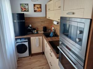 a small kitchen with a microwave and a dishwasher at Crystal Baltic Studio Gdańsk self check in - 24h in Gdańsk