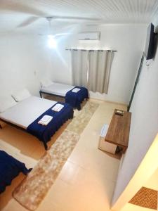 ein kleines Zimmer mit zwei Betten und einem Tisch in der Unterkunft Suíte Aconchegante na Natureza - RepousaAquiÓ in Olímpia