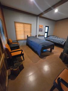 a bedroom with a bed and a couch and a chair at Bricks & Bed house pai in Ban Wiang Nua