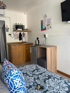 a room with a bed and a desk and a television at Magalies B&B LANGENHOVENPARK in Universitas +17 photos