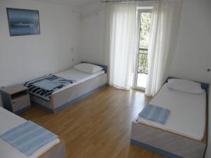 um quarto com 2 camas e uma janela com uma varanda em Guest House & Restaurant Adriatic Klek em Klek