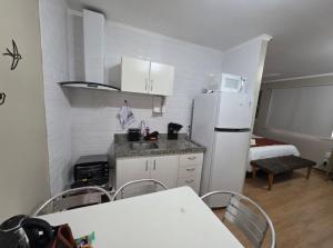 a kitchen with a white refrigerator and a table and chairs at Studio Sudoeste Ed Multiparque in Brasília +6 photos