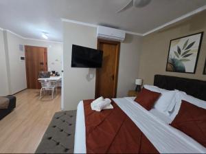 a bedroom with a large bed and a living room at Studio Sudoeste Ed Multiparque in Brasília