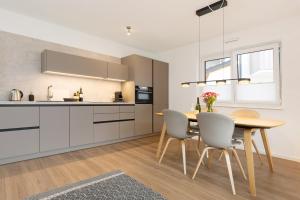 a kitchen and dining room with a table and chairs at Chiemsee Apartment 17 in Übersee