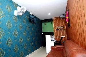 a living room with a couch and blue wallpaper at Sri Sai comforts - Bannerghatta Main Road in Bangalore