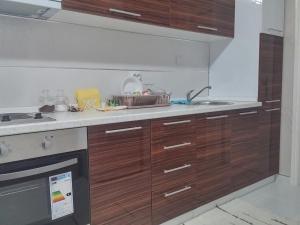 a kitchen with wooden cabinets and a sink at Apartman Sweet dreams 1 in Niš