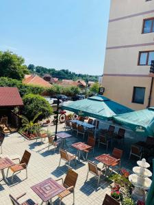 a patio with tables and chairs and a building at Pensiune Restaurant Indus in Ocna Sibiului