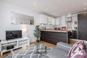 a living room with a couch and a kitchen at Roomspace Serviced Apartments - Abbot's Yard in Guildford