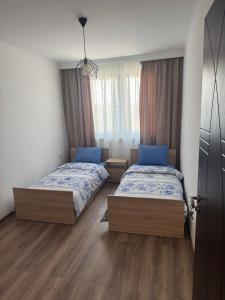 a bedroom with two beds and a window at Luxury House LUXIMMO in Lyetnitsa