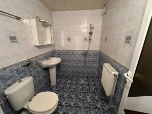 a bathroom with a toilet and a sink at Luxury House LUXIMMO in Lyetnitsa