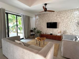 a living room with a couch and a ceiling fan at U PARADISU VILLAS - Private Pool in Jambiani +46 photos