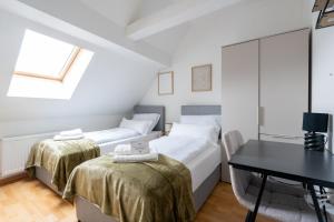 two beds in a room with a table and a desk at Large Maisonette I 90 m2 I For Groups & Families I 9 Guests I 3 Rooms in Kapfenberg +38 photos