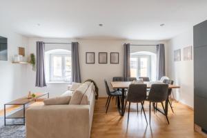 a living room with a couch and a table and chairs at Large Maisonette I 90 m2 I For Groups & Families I 9 Guests I 3 Rooms in Kapfenberg