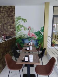 a restaurant with wooden tables and chairs and a flamingo on the wall at Hotel Elys in Pieve Emanuele