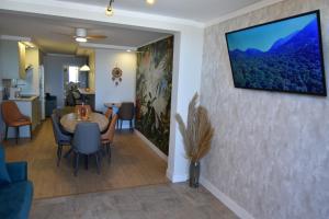 a living room with a table and a tv on a wall at Resort Villa Playa in Roquetas de Mar