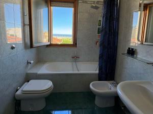 a bathroom with a tub and a toilet and a sink at Moderno Attico a due passi dal Mare in Senigallia