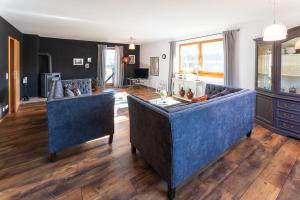 a living room with two blue couches at Ferienwohnung Lois ***** in Eggstätt