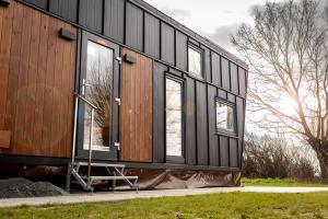 ein schwarzes Haus mit Fenstern an der Seite in der Unterkunft Tiny House - Rolling Tiny - Wanderfalke in Groß Kordshagen